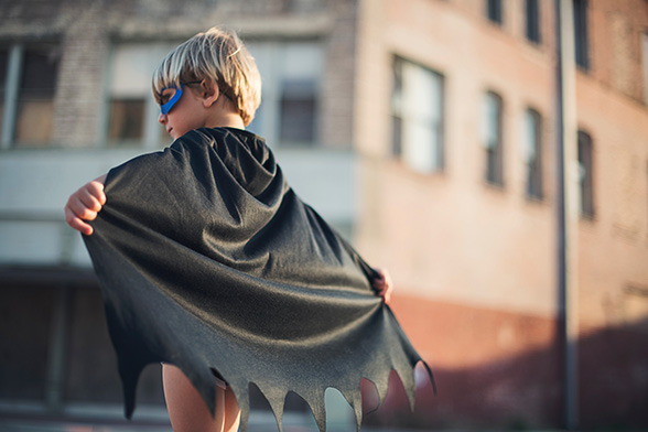 child with superhero cape